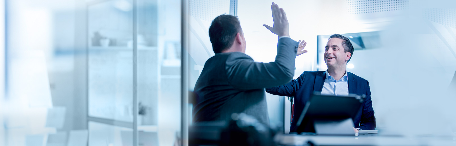 Two-men-high-five-at-office-partners-1920x615